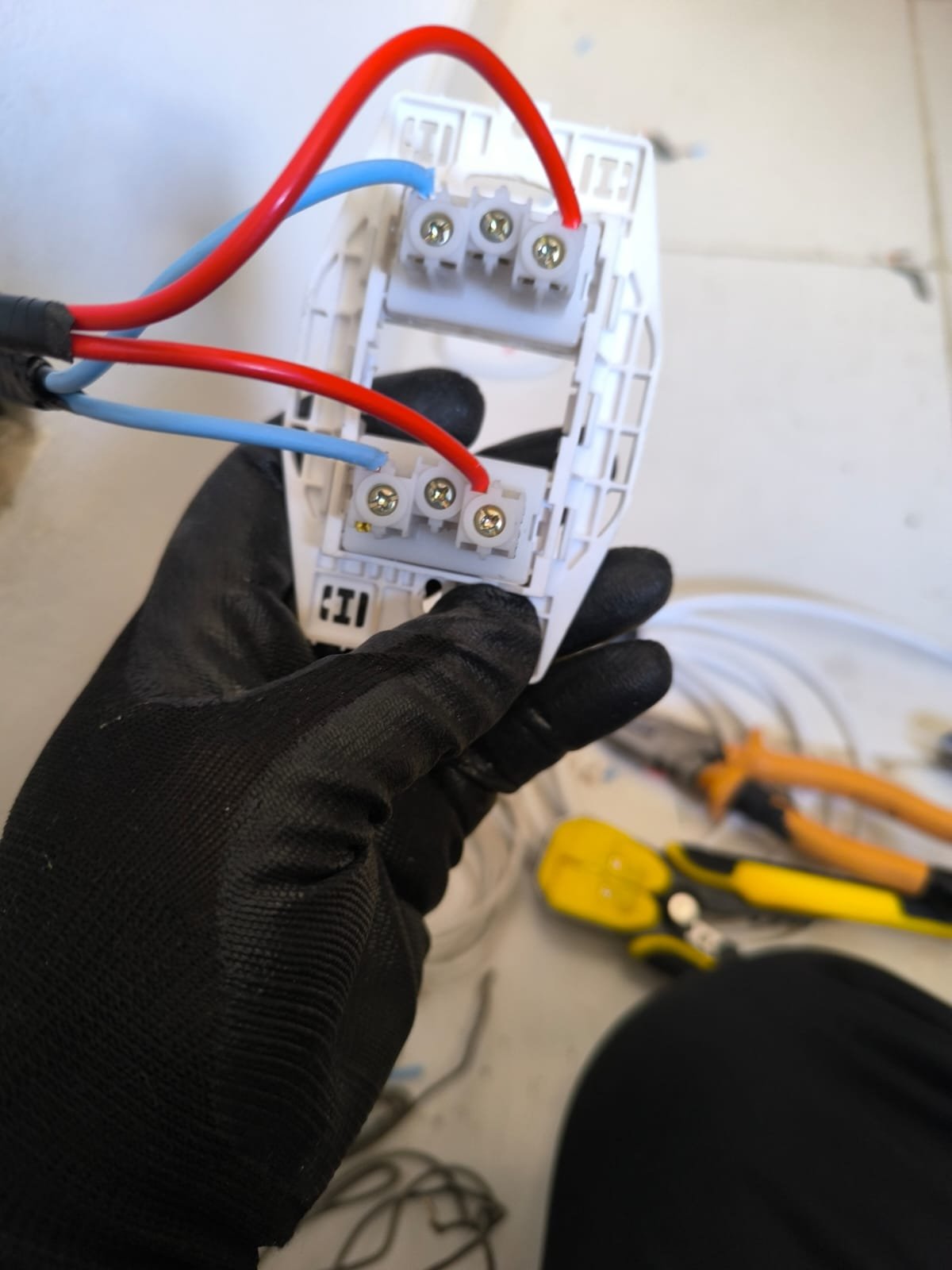 Eletricista realizando a conexão dos fios em um módulo de tomada