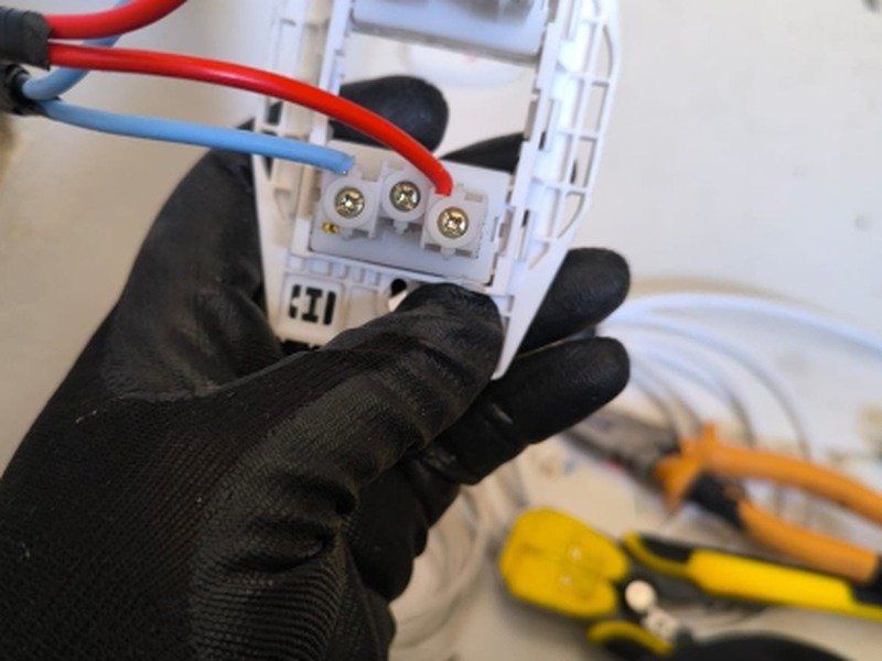 Eletricista conectando fiação de módulo de tomada e interruptor com ferramentas adequadas