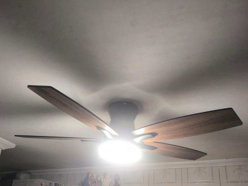 Ventilador de teto moderno com pás em madeira e luminária central LED instalado em ambiente residencial